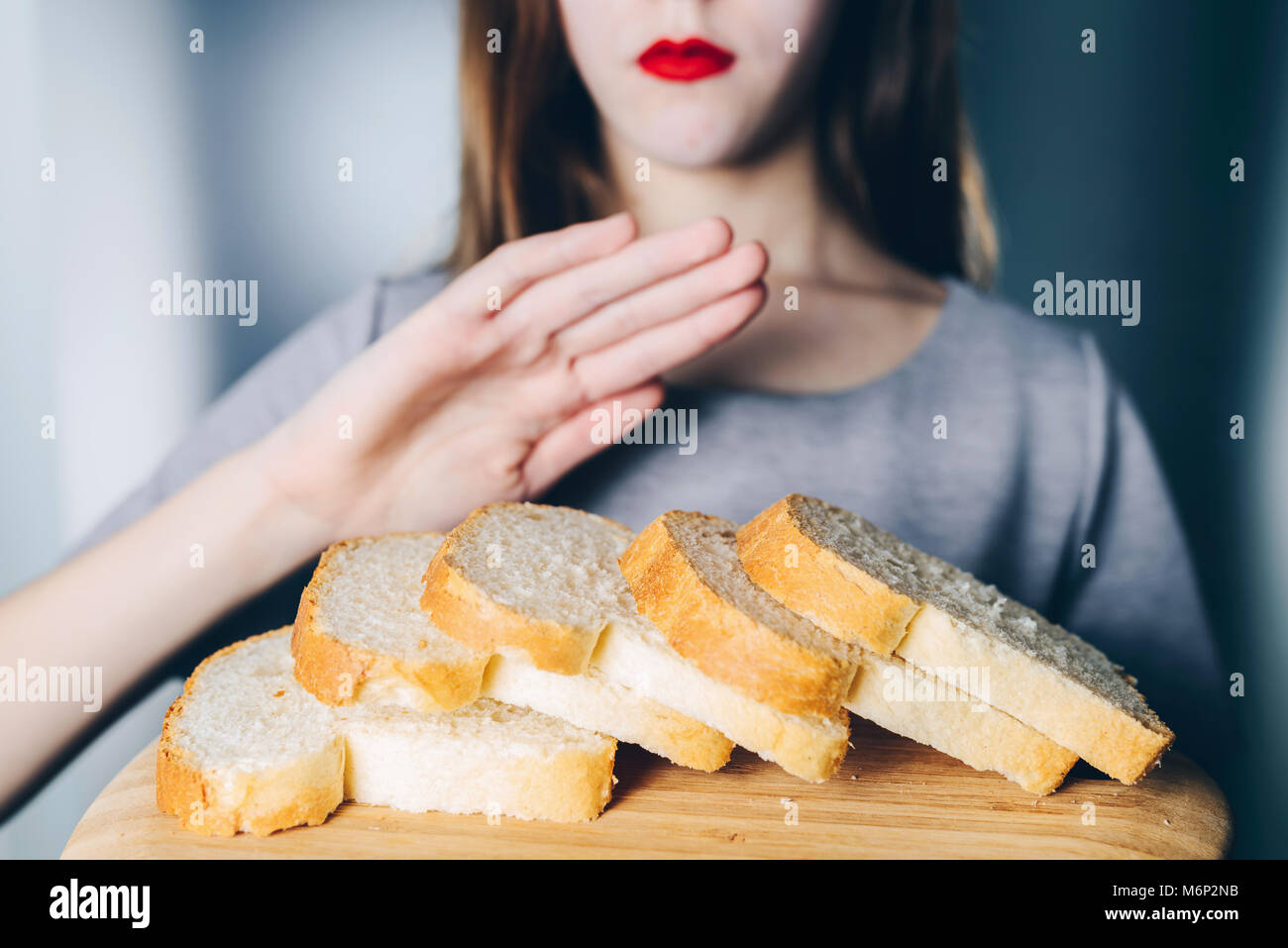 Intolleranza al glutine e concetto di dieta. Giovane ragazza si rifiuta di mangiare il pane bianco Foto Stock