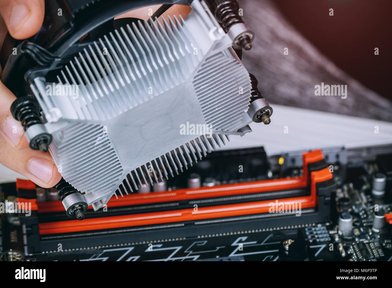 Le mani del tecnico installazione dello scambiatore di calore della CPU ventilatore su un computer pc scheda madre Bitcoin mining cryptocurrency con GPU rig. Bitcoins. Foto Stock