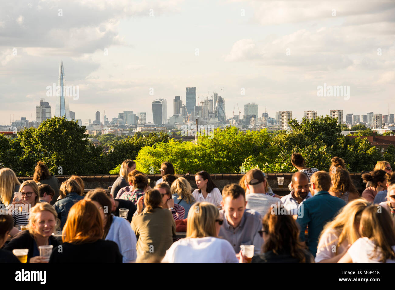 I giovani di socializzare e gustare un drink insieme a Franchi outdoor cafe bar sul tetto e ristorante in Peckham, Londra del sud con vista della città. Foto Stock