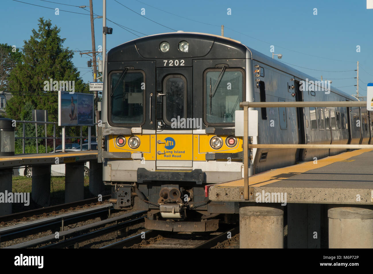 Long Island, NY - Circa 2017: Ferrovia di Long Island LIRR sit in treno alla stazione di piattaforma sulla giornata di sole la mattina. Commutare i viaggi ferroviari in Penn Station M Foto Stock