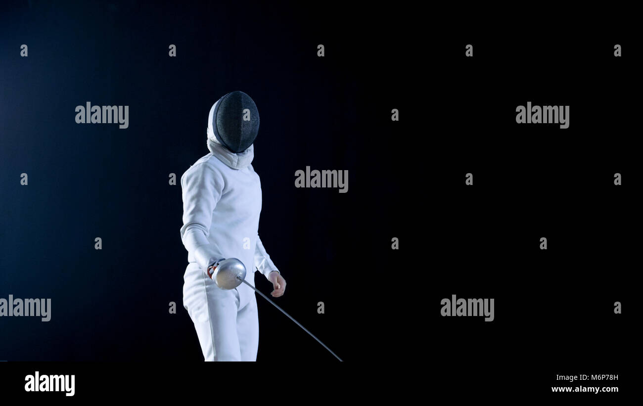 Completamente accessoriate esperti volante con formazione di una lamina. Egli pratica attacco, difesa, LEAP, spinta affondo e. Shot isolato su sfondo nero. Foto Stock