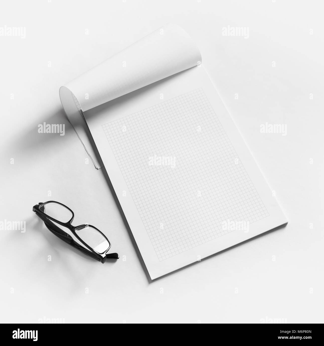 Blank copybook e bicchieri sul libro bianco sullo sfondo. Design sensibile mockup. Foto Stock