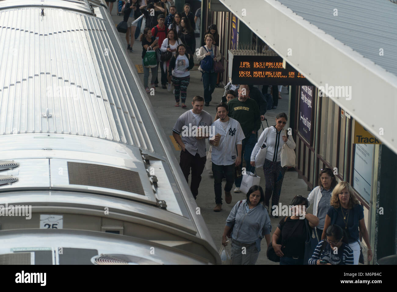 La città di New York, circa 2017: persone uscire dalla Ferrovia di Long Island stazione ferroviaria piattaforma. Gli appassionati di baseball jersey usura utilizzare i trasporti pubblici per allietare favore Foto Stock