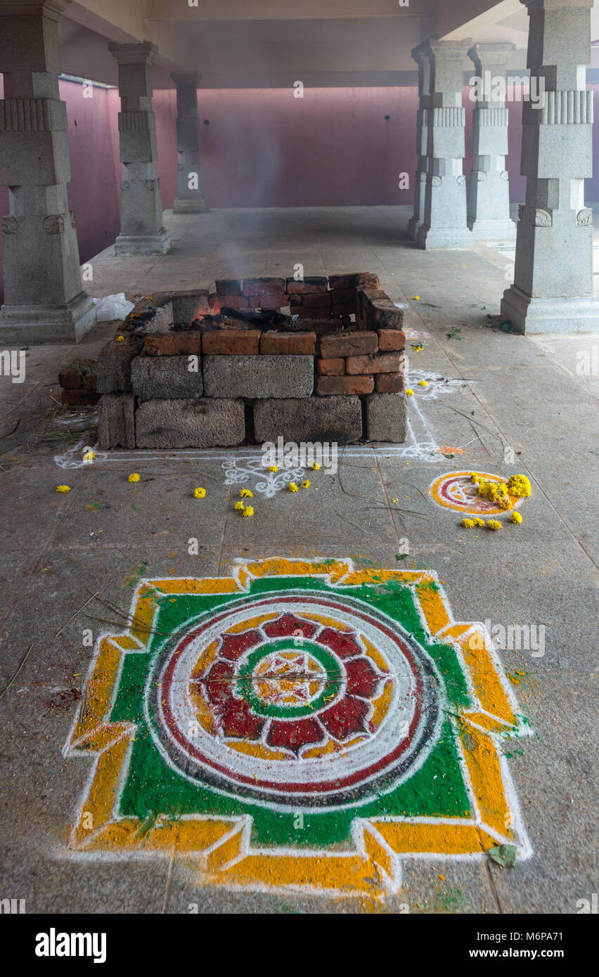 Talakaveri, India - 31 Ottobre 2013: pietra squadrata una buca per il fuoco in cui le offerte sono bruciati e colorato pavimento Rangoli pittura presso Talakaveri, la molla Foto Stock