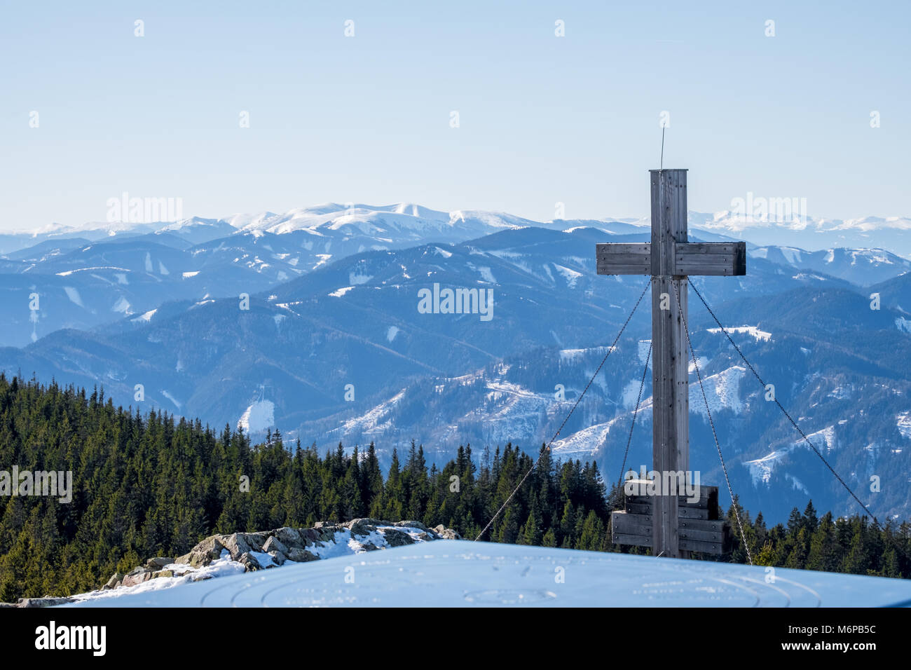 Panoramica paesaggio innevato vista panoramica dalla cima del monte Rennfeld con croce e lontane cime di montagna e Wenzelaple Rosseck in inverno Foto Stock