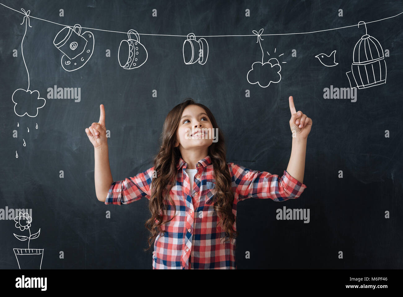 Ragazza creativa che mostra il suo nuovo disegno inusuale e guardando eccitato Foto Stock
