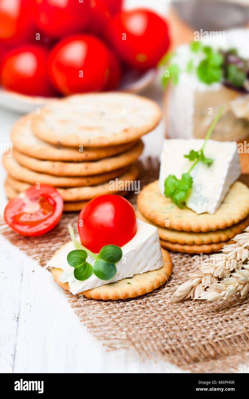 I cracker e il cuneo di blu formaggio camembert su un letto di sacco igienico Foto Stock