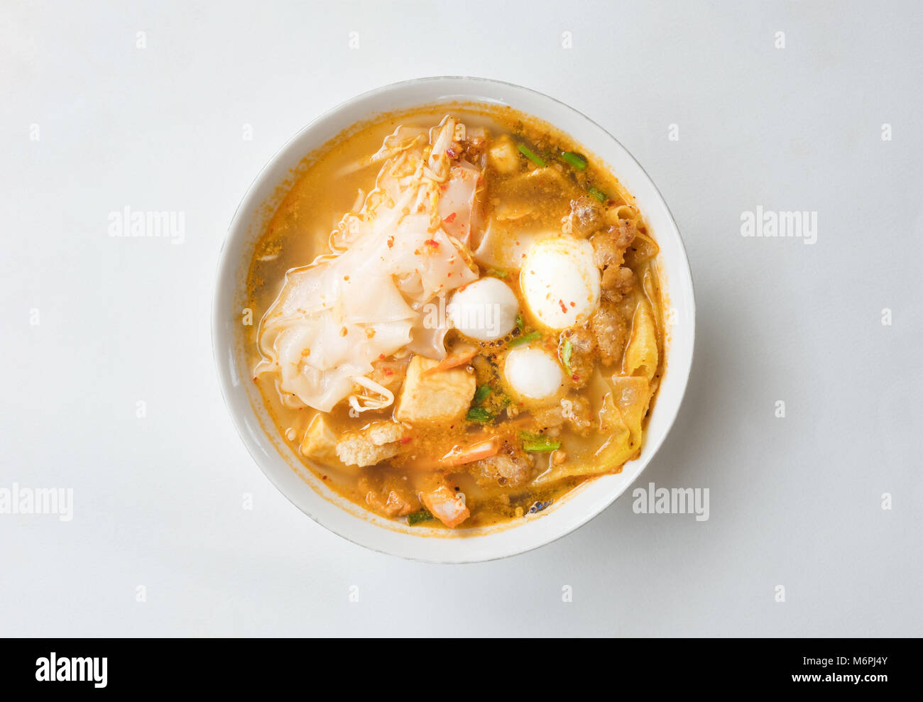 Vista dall'alto di piccante Tom Yam di maiale zuppa di noodle isolato su sfondo bianco con tracciato di ritaglio Foto Stock