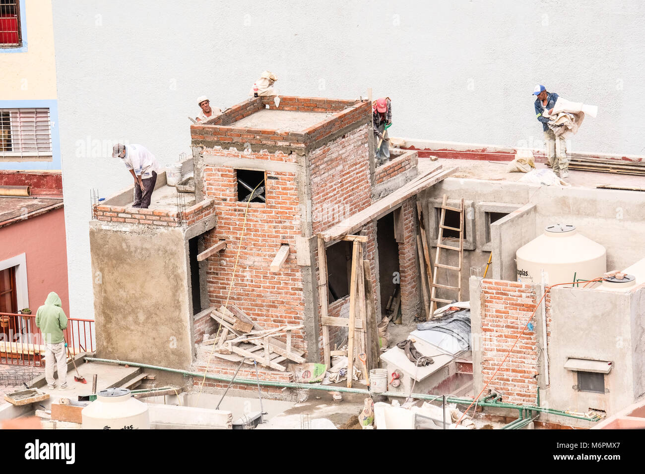 Costruzione messicano i lavoratori che operano su una metà tetto finito in Guanajuato, Messico Foto Stock