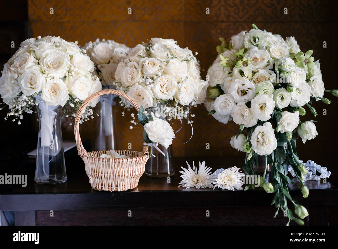 Bouquet per la sposa e le sue damigelle hanno con cesto di petali di rose Foto Stock
