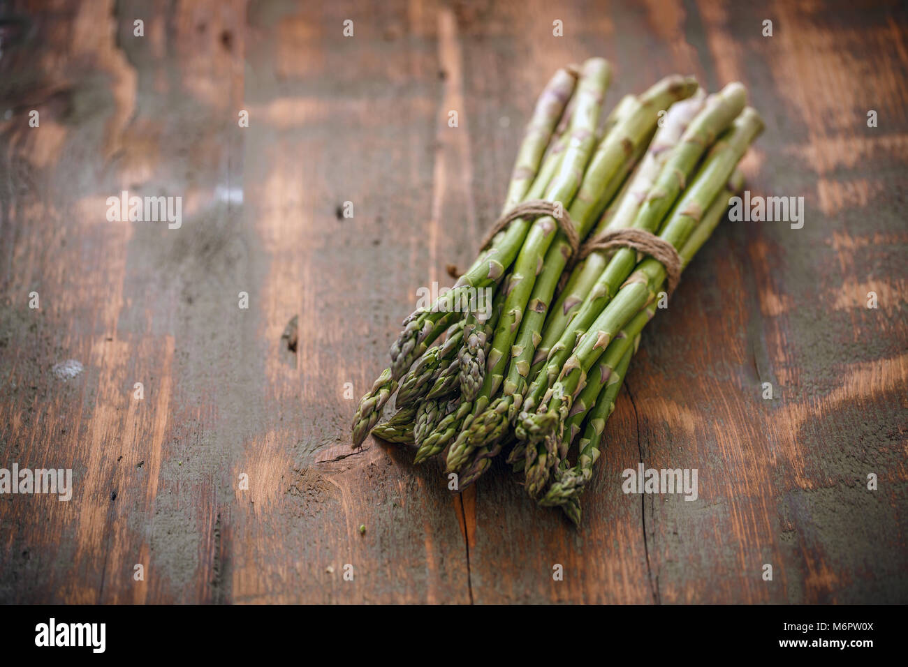 Freschi asparagi verdi grappoli su rustico sfondo di legno Foto Stock