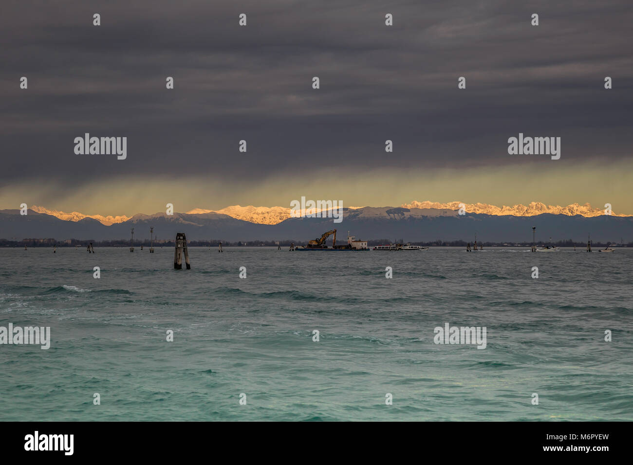 Laguna veneziana durante una tempesta sullo sfondo delle Alpi innevate soleggiato Foto Stock