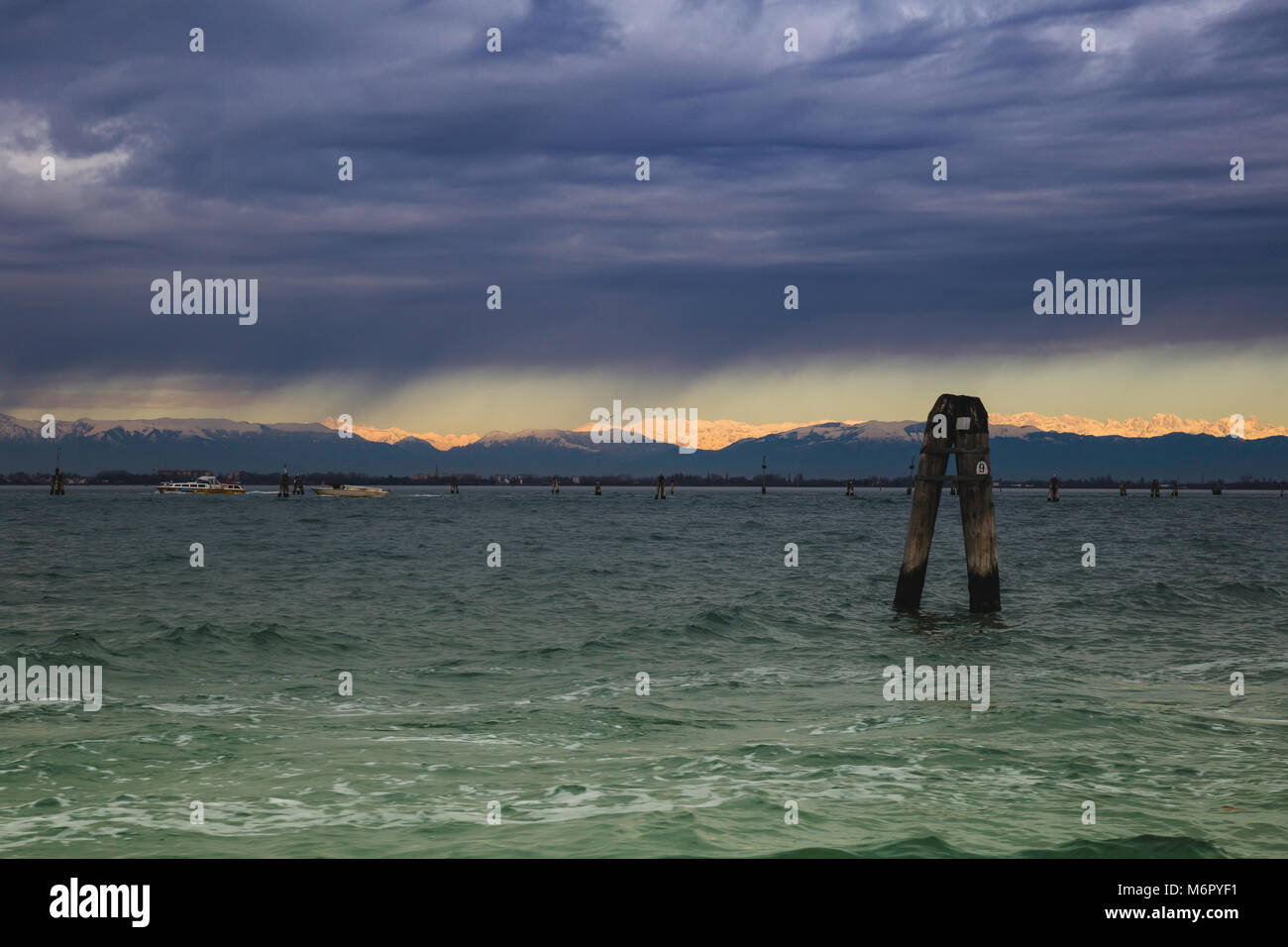 Laguna veneziana durante una tempesta sullo sfondo delle Alpi innevate soleggiato Foto Stock