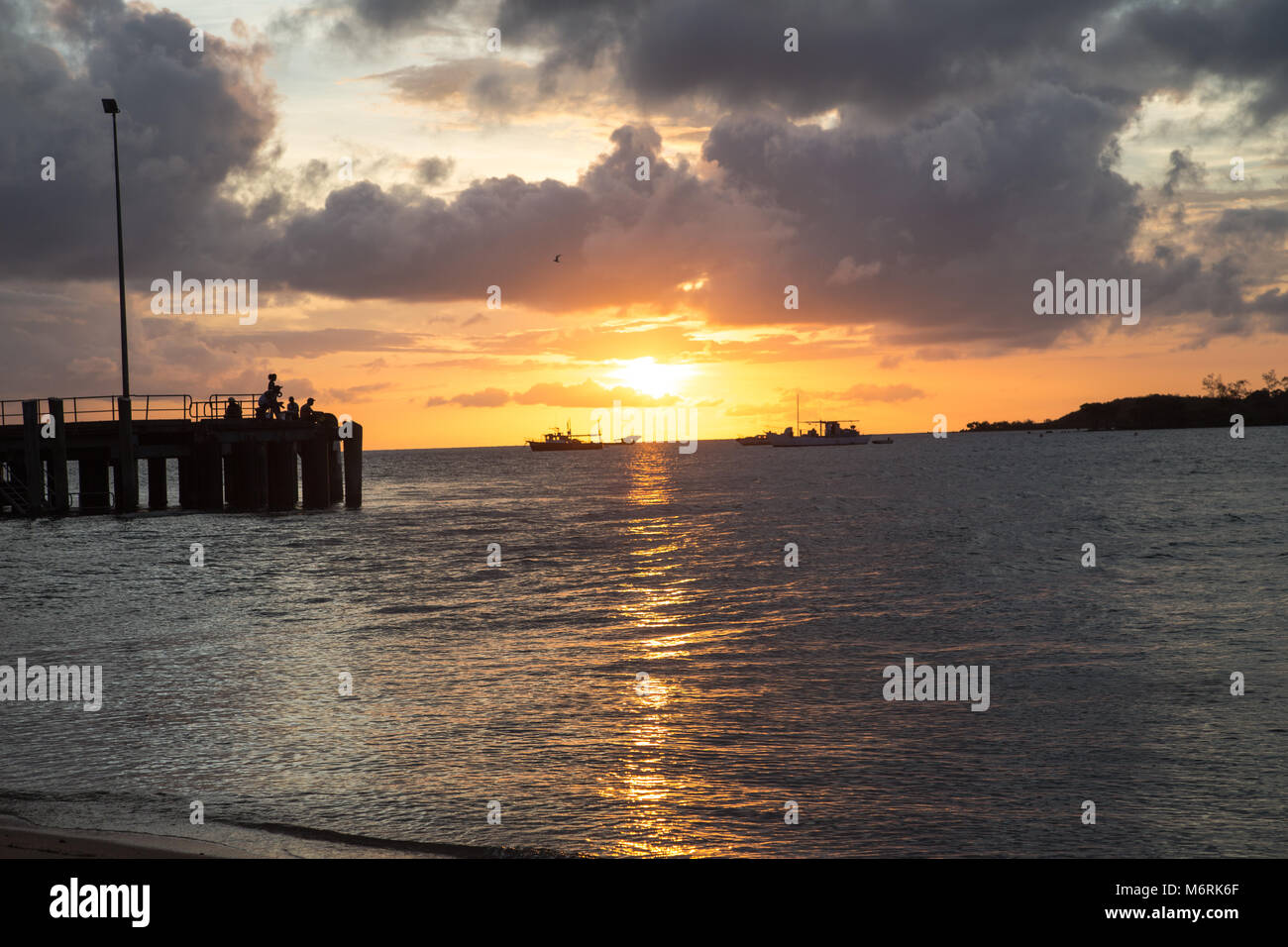 Bamaga Cape York Australia tramonto sull'oceano, pontile principale sotto il cielo nuvoloso Foto Stock