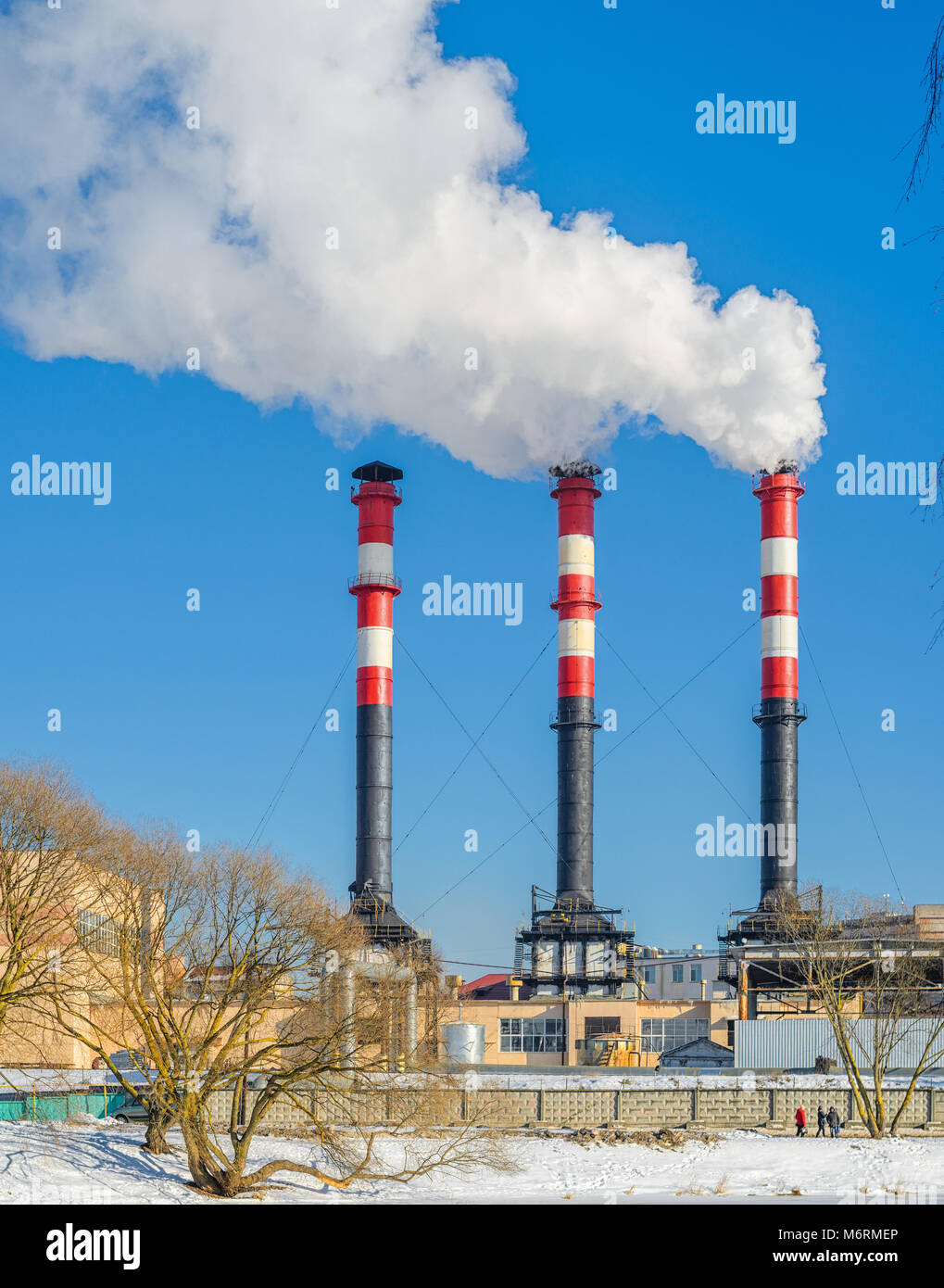 Centrale termica durante il funzionamento in inverno. Alti comignoli emettono una grande quantità di fumo Foto Stock