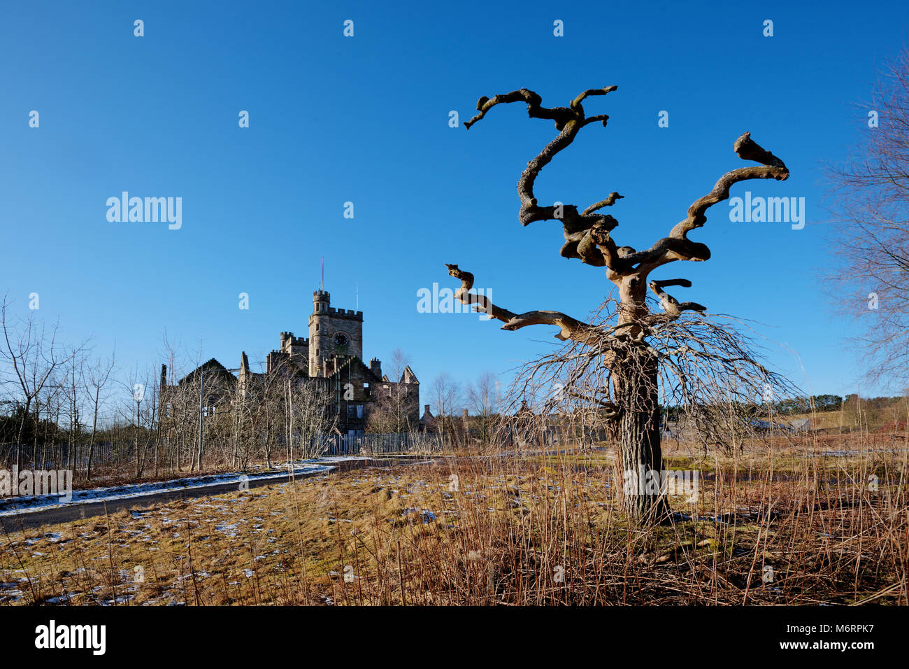 Inusuale struttura sagomata presso il sito remoto in villaggio Hatwood in Lanarkshire con il vecchio ospedale abbandonato in background. Foto Stock