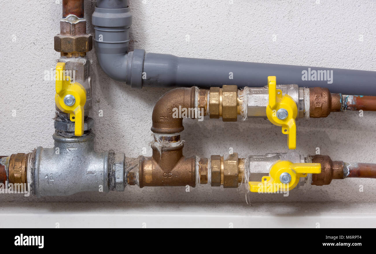 Rame e plastica Tubazioni e valvole di giallo in un locale caldaia Foto Stock