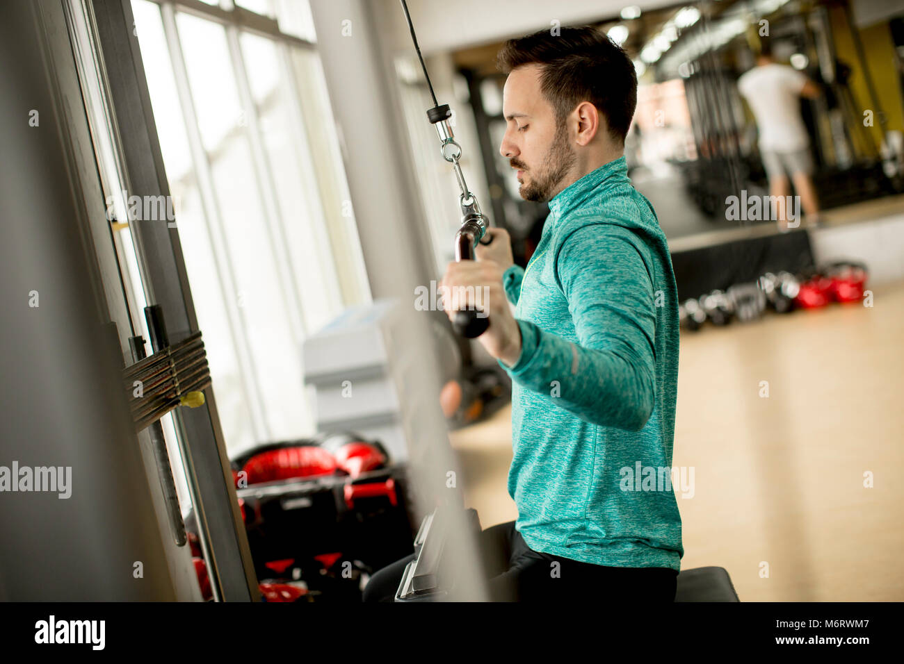 Uomo bello fare excersise su un lat machine in palestra Foto Stock