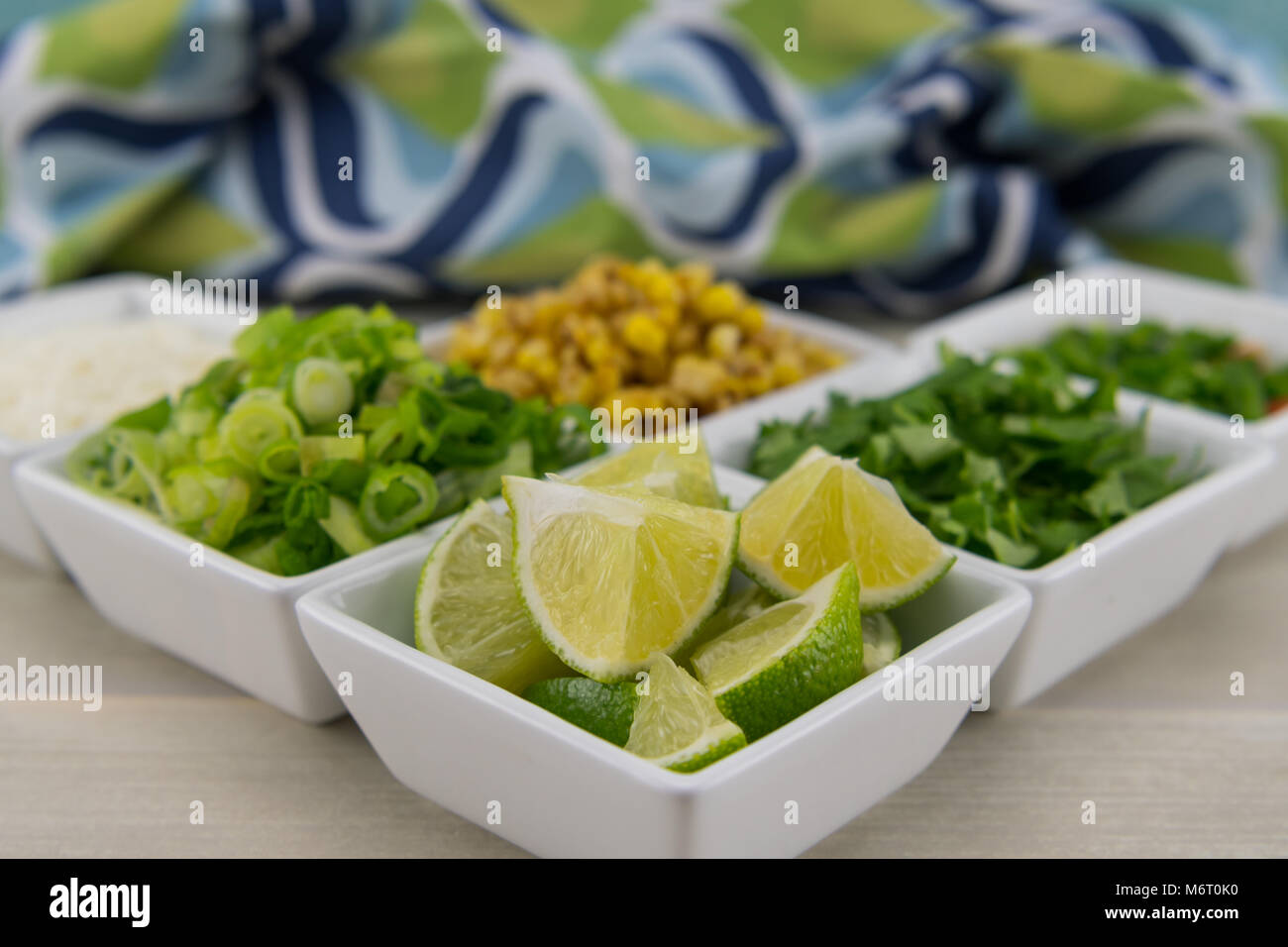 Piccoli spicchi di lime Close Up con altri condimenti per fajita dietro Foto Stock
