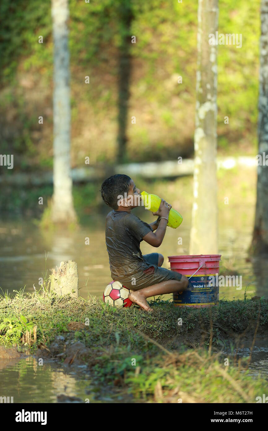 Infanzia felice, fango giocare a calcio, divertirsi con la natura e godere di infanzia, bambini calcio,memorie, divertirsi, ciclo di bambini, albero con ragazzo, gioco Foto Stock