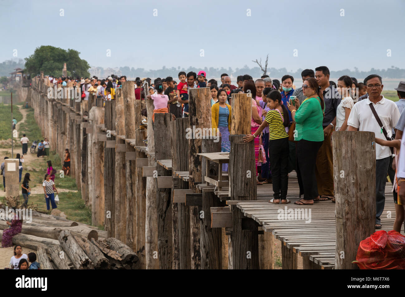 Un sacco di persone all'U Bein Bridge ad Amarapura vicino a Mandalay in Myanmar (Birmania) al tramonto. È il più antico e il più lungo ponte in teak nel mondo. Foto Stock