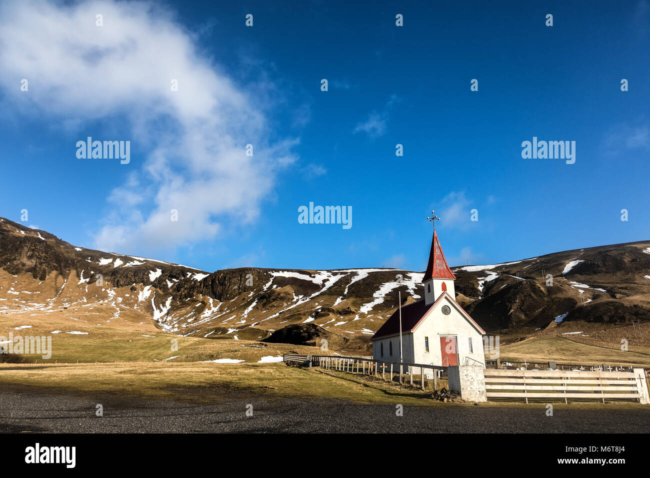 Vista della tipica chiesa islandese accanto a una montagna. Foto Stock