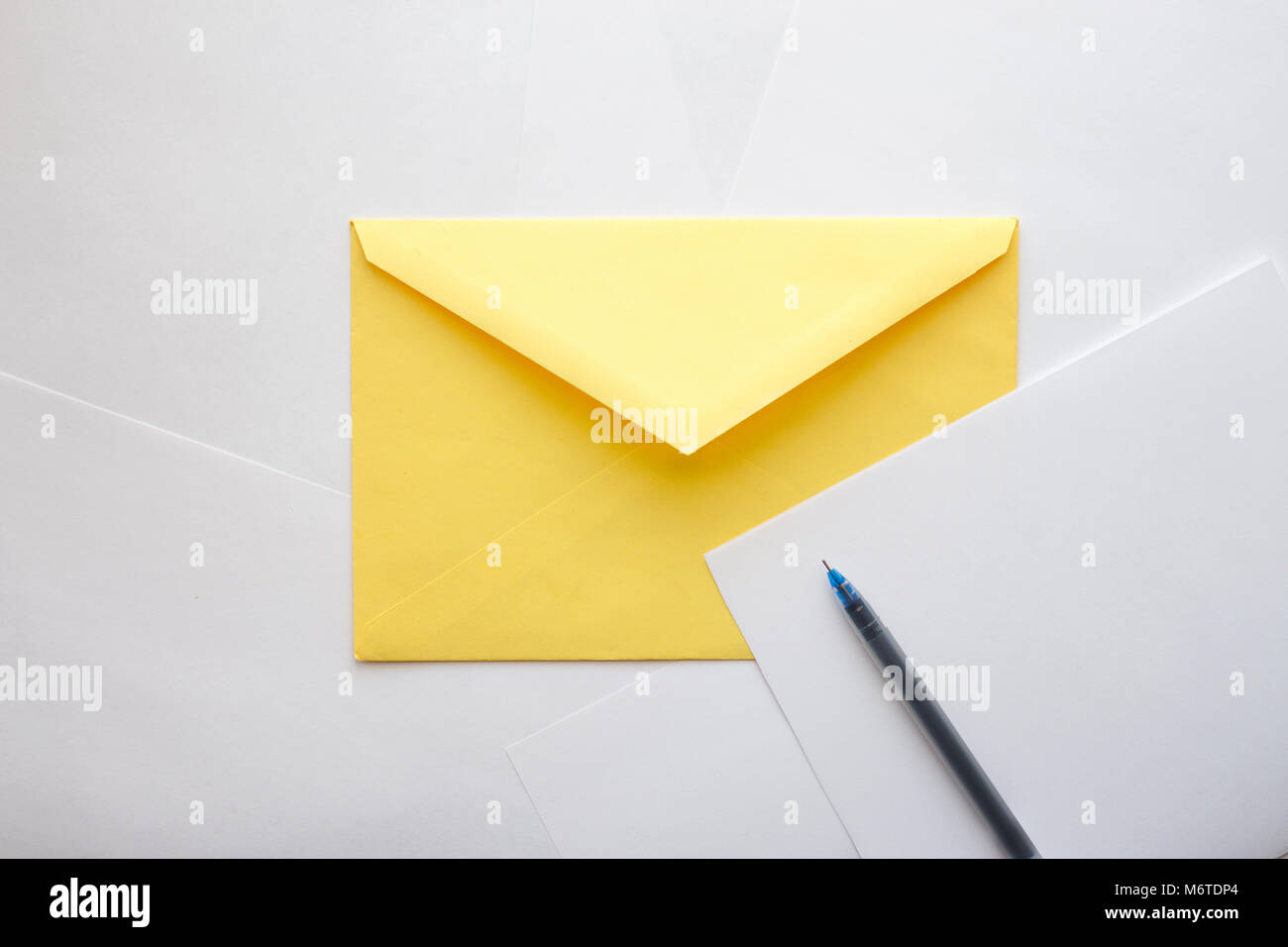 Giallo busta di carta e un pezzo di carta per scrivere una lettera con la  penna sono in attesa per la scrittura e invio Foto stock - Alamy
