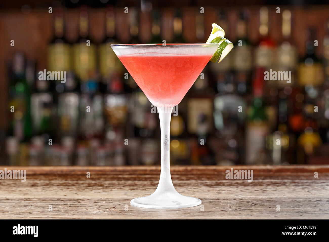 Un cosmopolita cocktail alcolico è sulla barra in un ristorante o in un club. Sfocare lo sfondo di alcol. Foto Stock