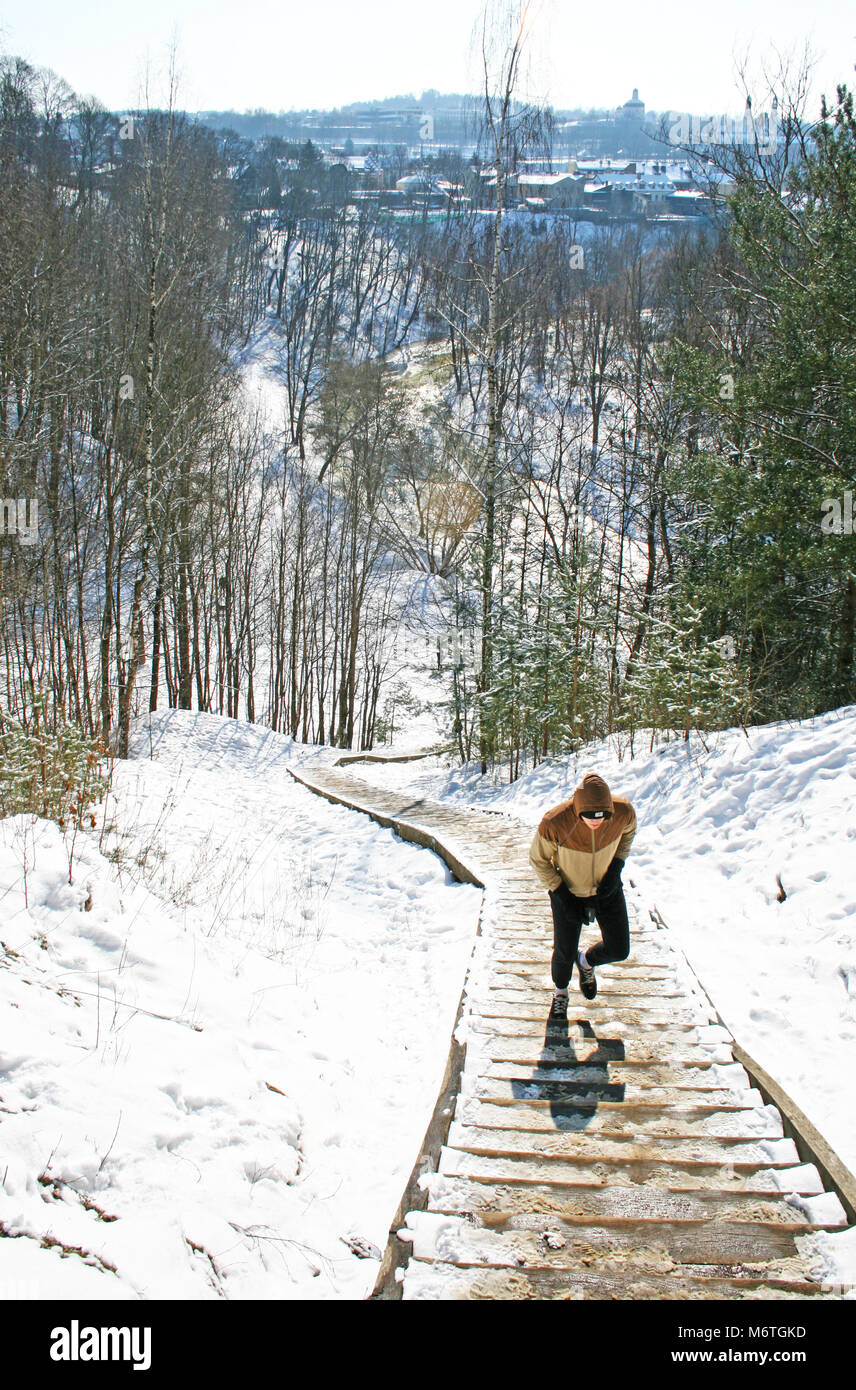 L'uomo salire la collina, trail running, corsa in montagna in inverno Foto Stock