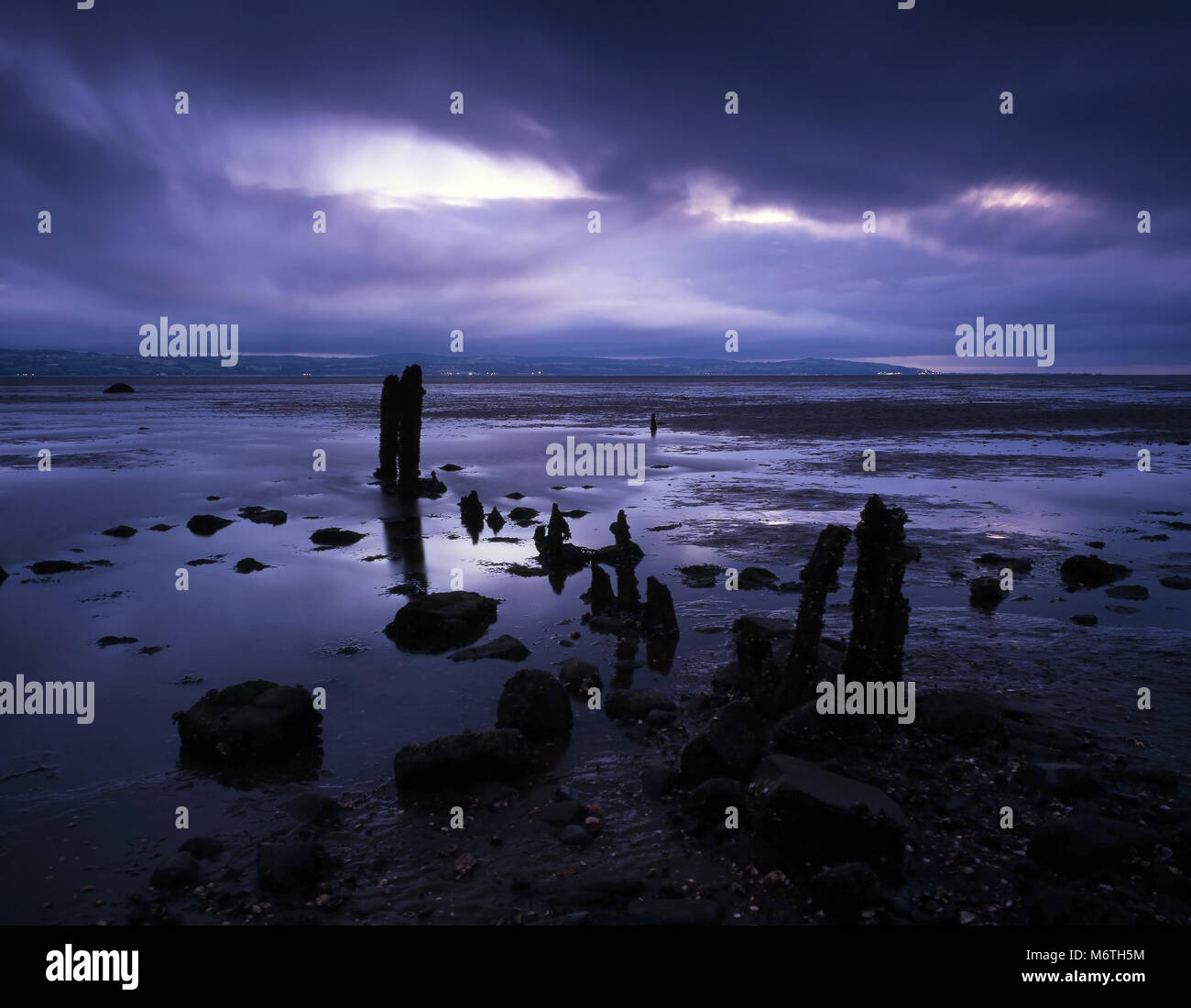 Un crepuscolo vista della costa lungo la penisola di Wirral, guardando attraverso le Dee estuario verso il nord del Galles, UK. Foto Stock