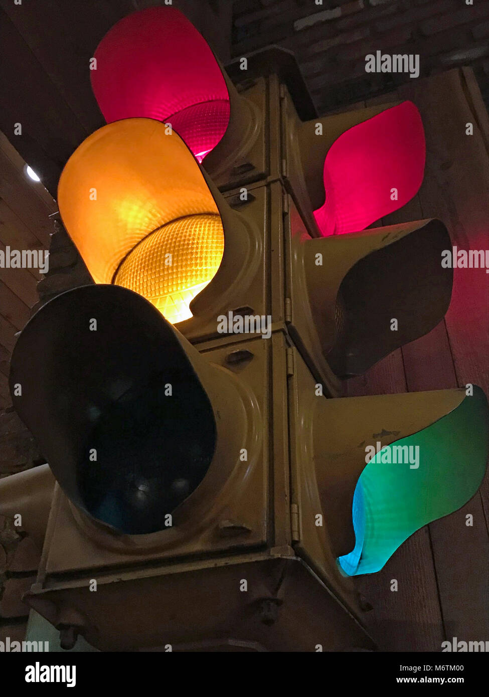 Segnale di traffico illuminata con due luci rosse, una luce verde e una luce gialla Foto Stock