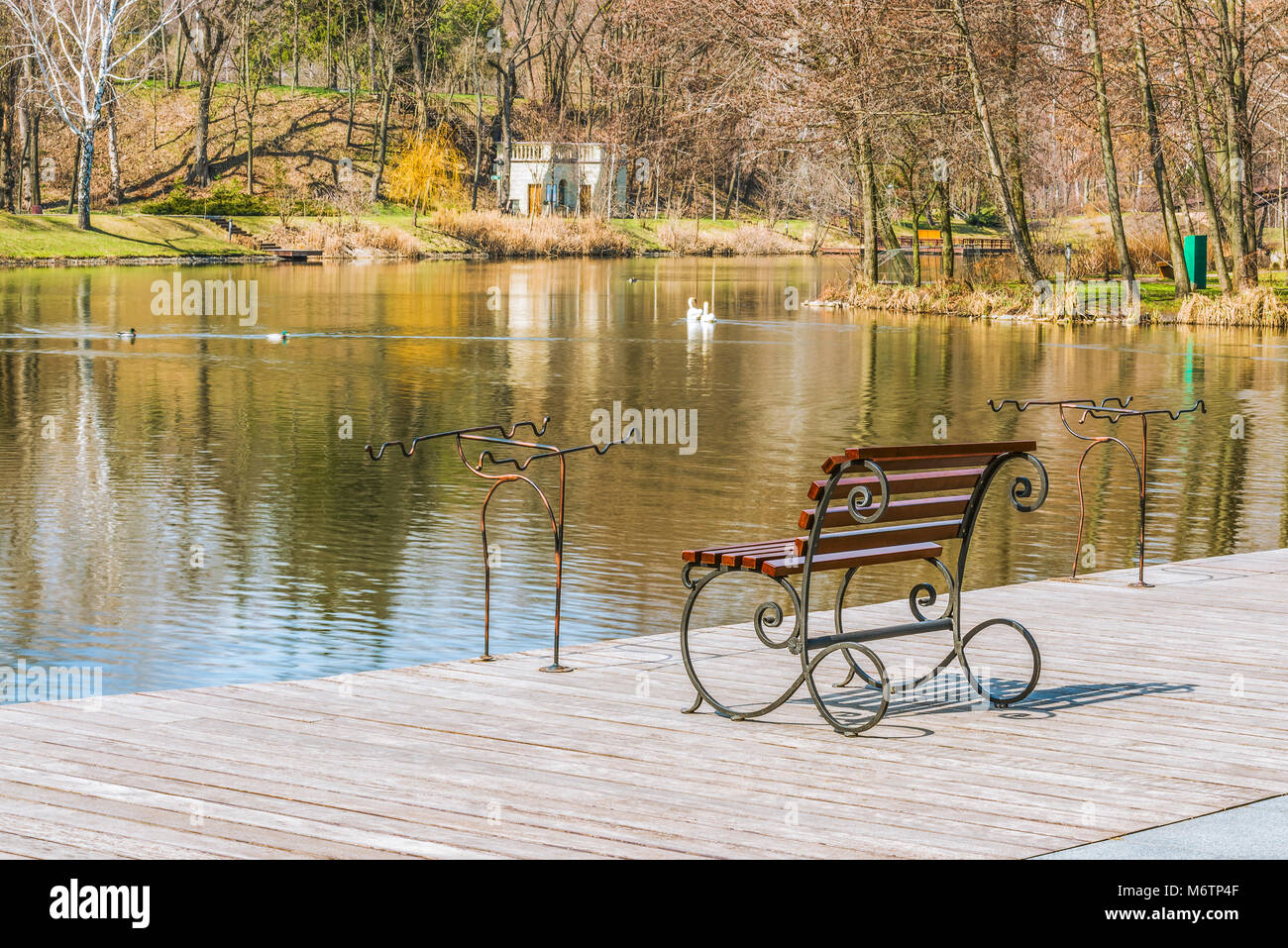 Un pescatore del luogo in riva al lago su una chiara giornata di sole in primavera. Luoghi per canne da pesca, pesca sedile, molo in legno. Il concetto di o Foto Stock