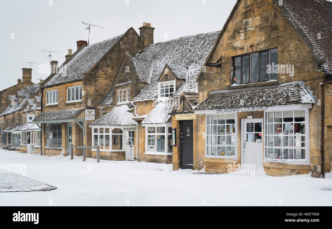 Negozi a broadway nella neve d'inverno. Broadway, Cotswolds, Worcestershire, Inghilterra Foto Stock