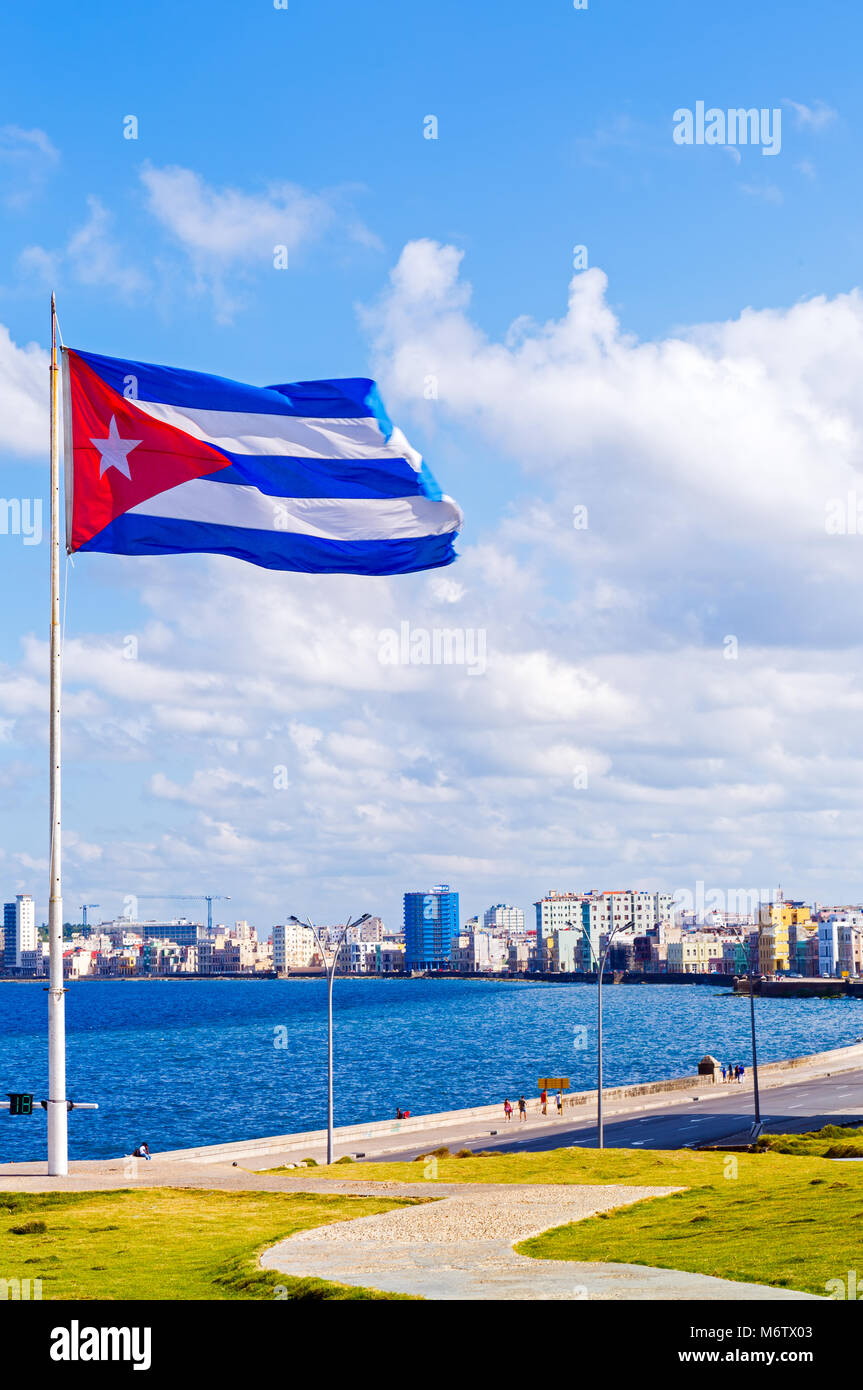 Bandiera cubana che si affaccia sul Malecon con l'Avana skyline della città in background Foto Stock