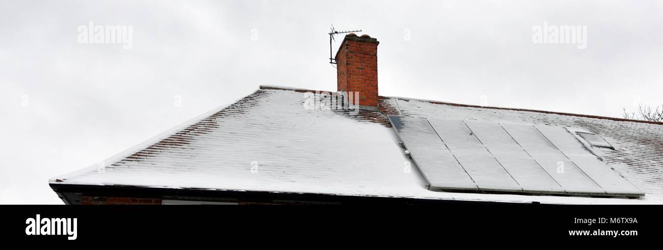Pannelli fotovoltaici su un tetto coperto di neve Foto Stock