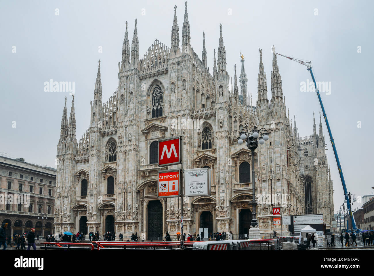 Facciata gotica del Duomo di Milano in Piazza del Duomo con lampade e segno della metropolitana e la linea M1 ingresso Foto Stock