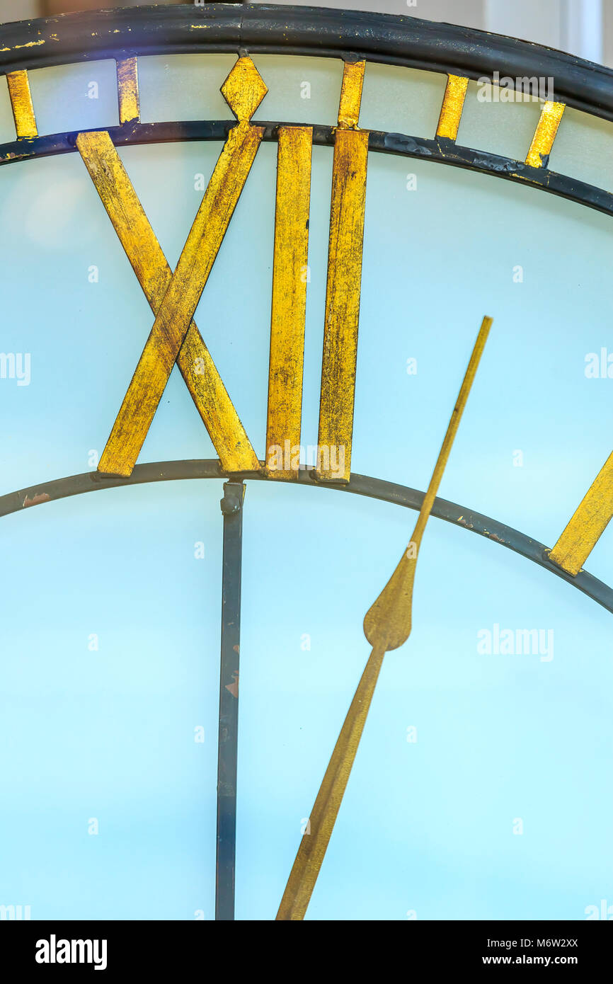 Un orologio bianco con oro dita che mostra il tempo a solo dopo dodici ore mezzanotte o mezzogiorno. Foto Stock