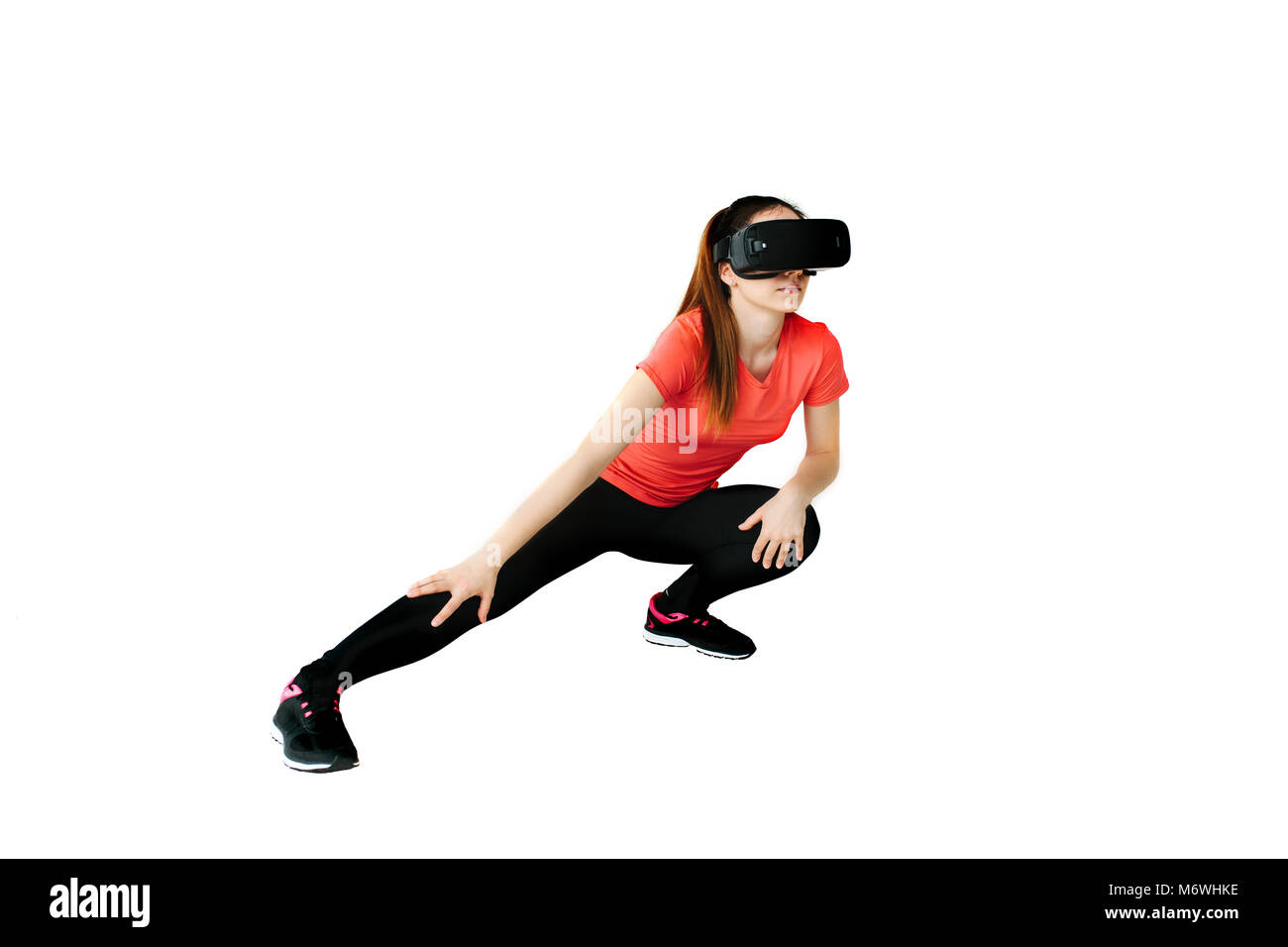 Una giovane bella donna di occhiali per realtà virtuale rende aerobica in remoto. La tecnologia del futuro concetto. Le classi in unico sport in remoto. Su un bianco b Foto Stock