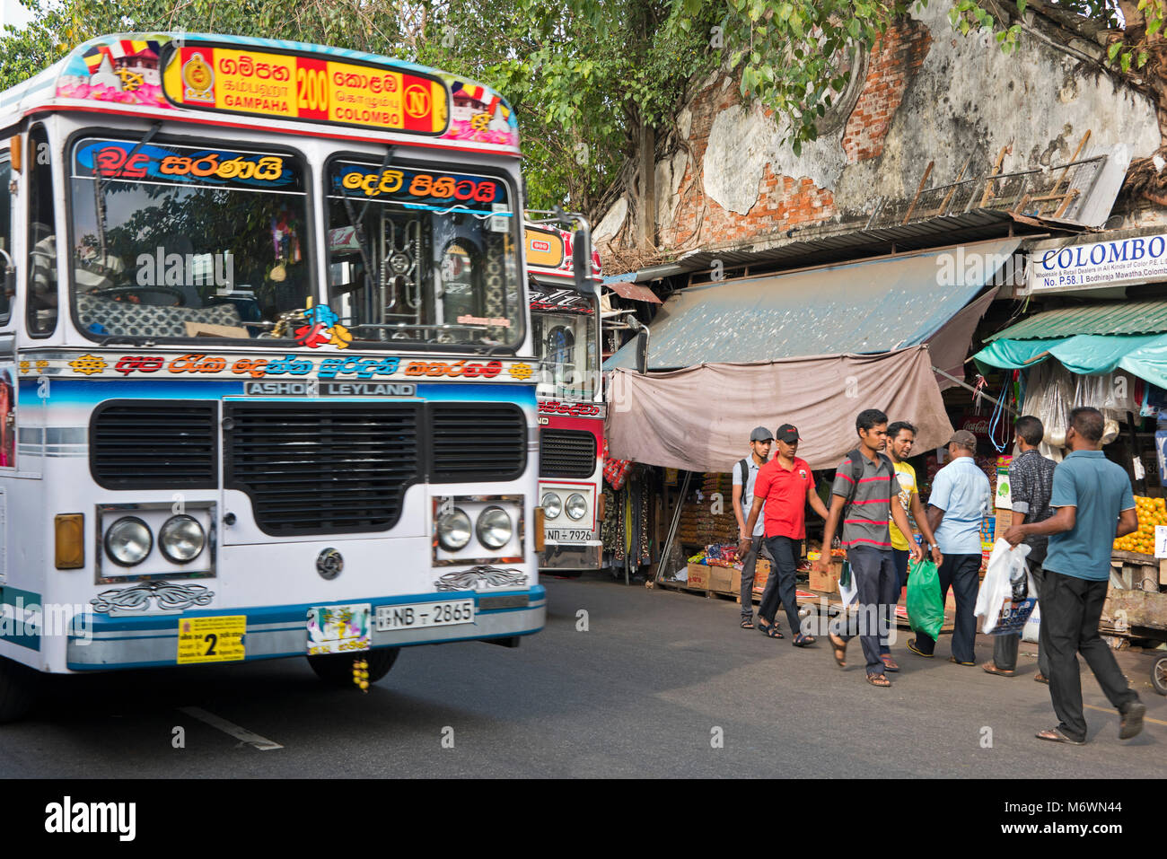 Streetview orizzontale di autobus pubblici di guida attraverso un mercato occupato in Colombo, Sri Lanka. Foto Stock