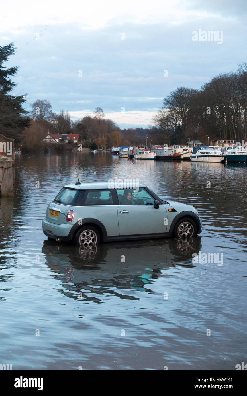 Automobilista / Mini auto autista taglia bene in salita rapidamente acqua come Spring Tide sul Tamigi rischia di sopraffare e inondare la sua auto. (95) Foto Stock