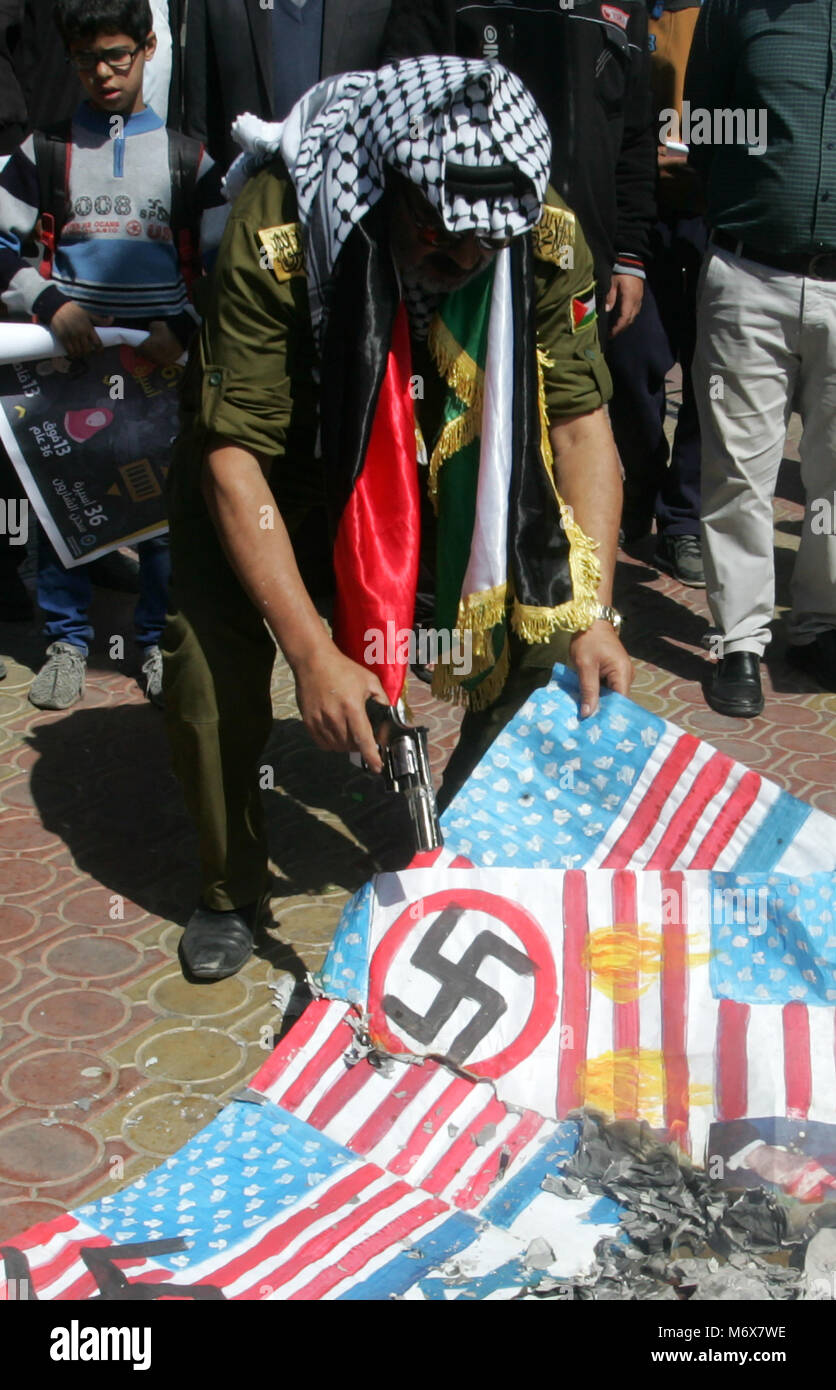 La striscia di Gaza, Territori palestinesi. 07 marzo, 2018. Un palestinese ustioni di rappresentazioni di Stati Uniti e israeliane e Gran Bretagna bandiere durante una manifestazione di protesta contro la U.S. Presidente Donald Trump la decisione in Gerusalemme in vista della Giornata internazionale della donna, a Rafah nel sud della striscia di Gaza, in data 7 marzo 2018. Credito; Abed Rahim Khatib / risveglio / Alamy Live News Foto Stock