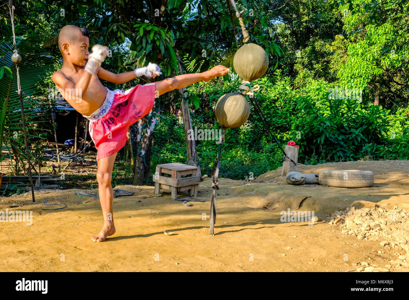 A sette anni vecchio ragazzo di formazione è la sua abilità di kickboxing da calci sfere Foto Stock