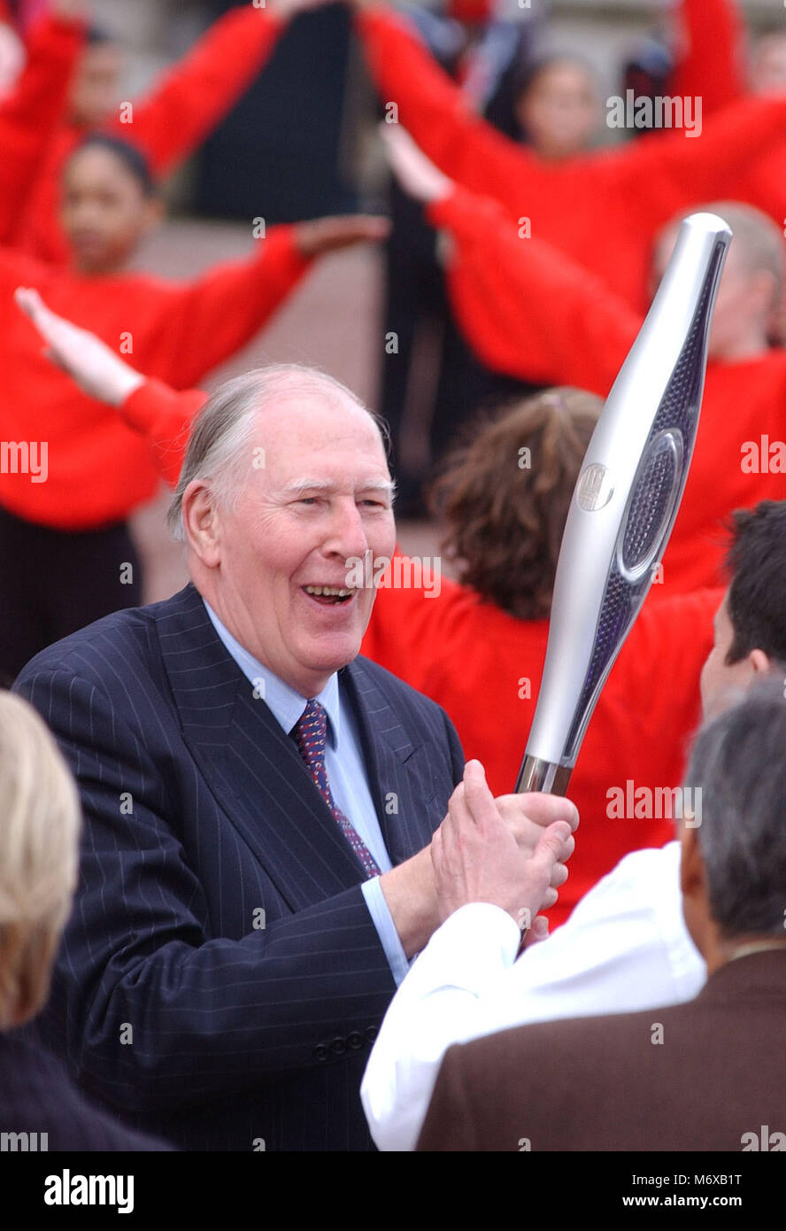 ©ALFA 047070 11_03_01 Sir Roger Bannister mani al di sopra del Commonwealth testimone a Sebastian Coe in piazzale del Buckingham Palace di Londra. In una spettacolare send-off, completa con fuochi d'artificio dal tetto di Buckingham Palace, palloncini e mini concerto pop, la regina ha consegnato la Manchester giochi hi-tech testimone a Sir Roger, il primo uomo a percorrere un miglio in meno di quattro minuti. È stata la star-studded inizio di un 58,000-mile relè intorno al mondo, attraverso 23 paesi del Commonwealth e torna al Regno Unito per il mese di luglio 25 apertura dei Giochi, che avrà luogo a Manchester. Foto Stock