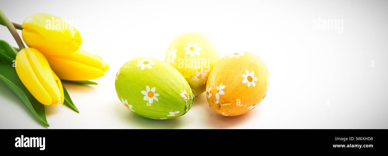 Tre uova di pasqua con tulipani gialli Foto Stock