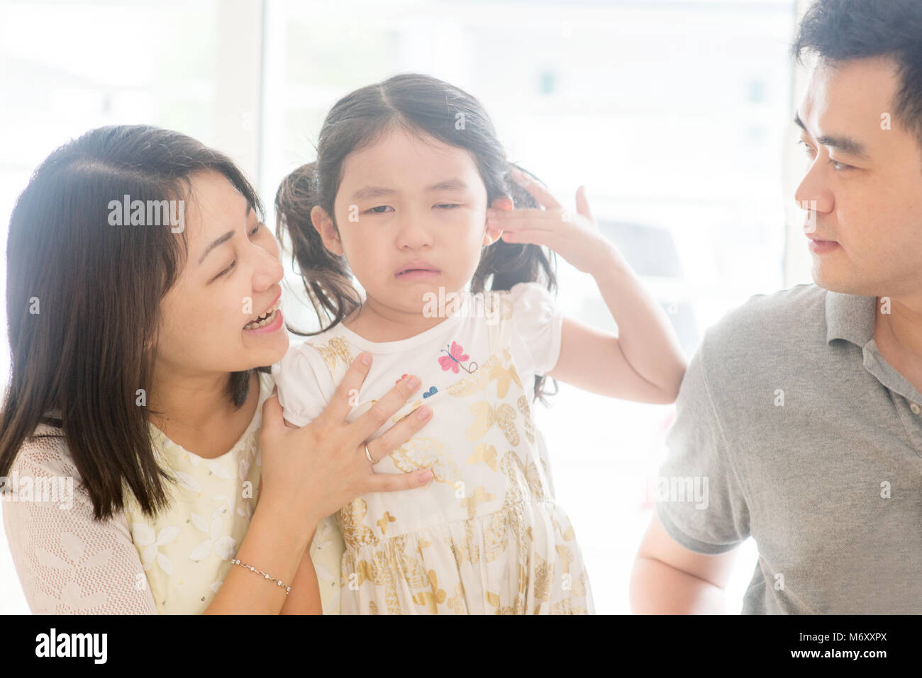 I genitori consolante Gridando bambino. Famiglia asiatica a casa, una vita naturale stile di vita in ambienti chiusi. Foto Stock