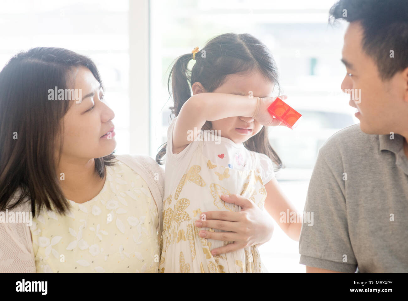 I genitori di conforto a piangere la figlia. Famiglia asiatica a casa, una vita naturale stile di vita in ambienti chiusi. Foto Stock