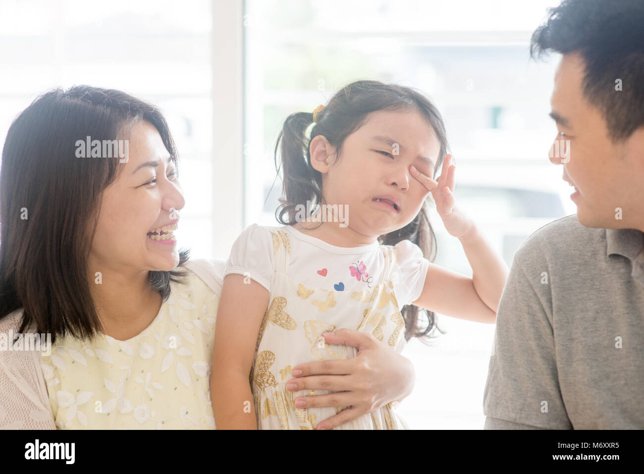 Il padre e la madre di conforto a piangere la figlia. Famiglia asiatica a casa, una vita naturale stile di vita in ambienti chiusi. Foto Stock