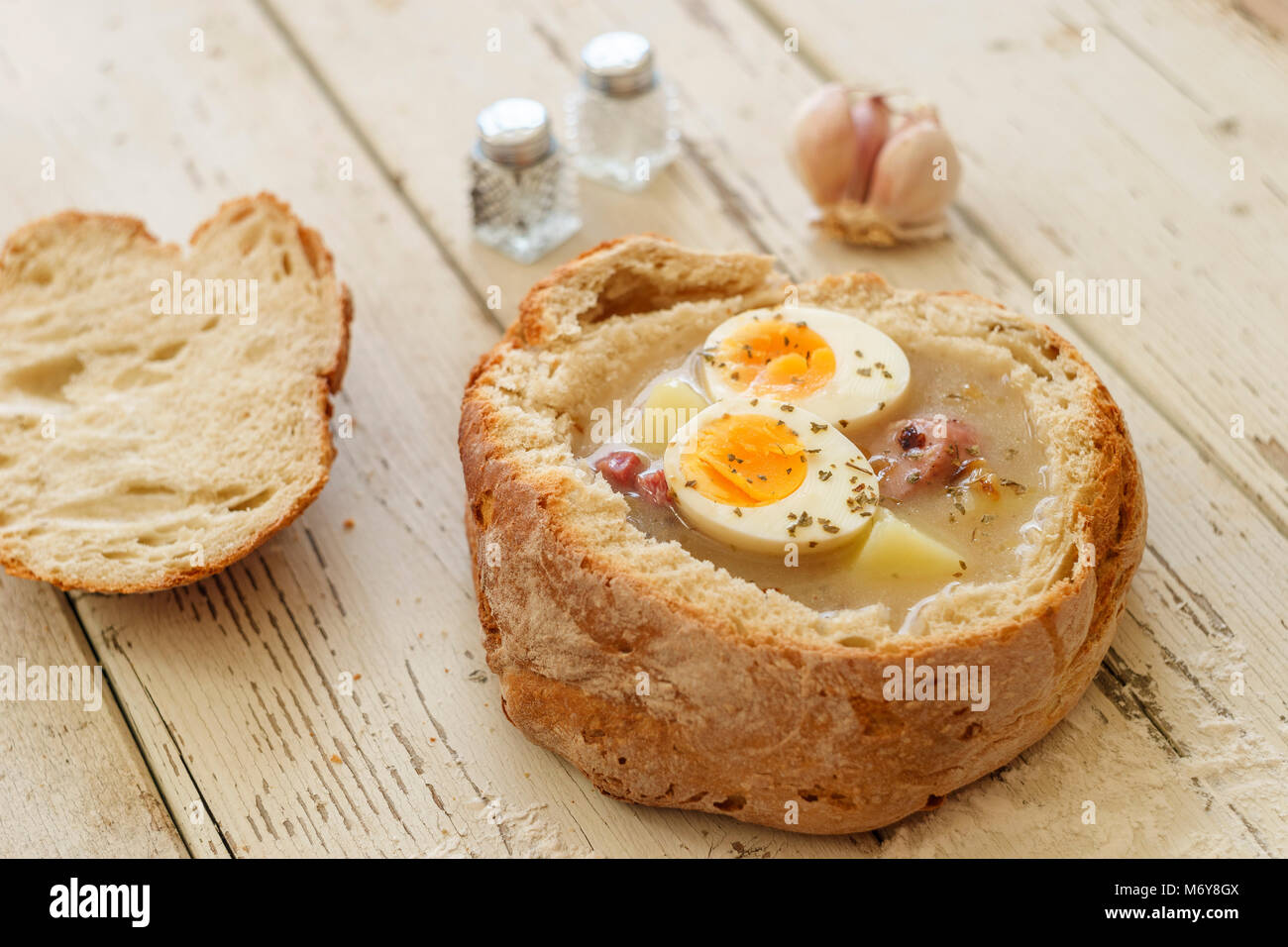 Tradizionale zuppa di polacco chiamato Zurek con uova e salsiccia su sfondo di legno Foto Stock