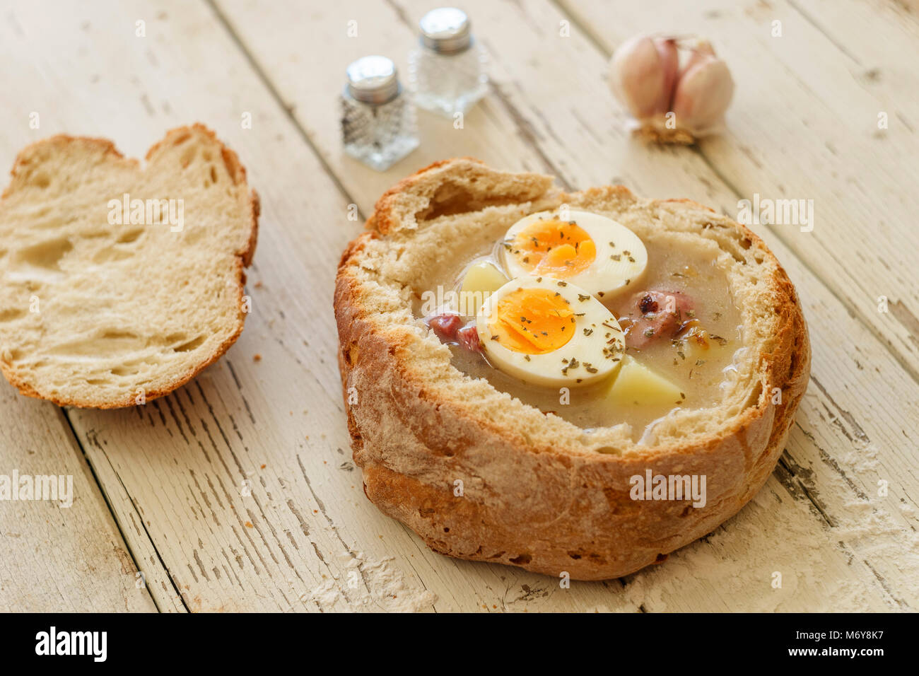 Tradizionale zuppa di polacco chiamato Zurek con uova e salsiccia su sfondo di legno Foto Stock