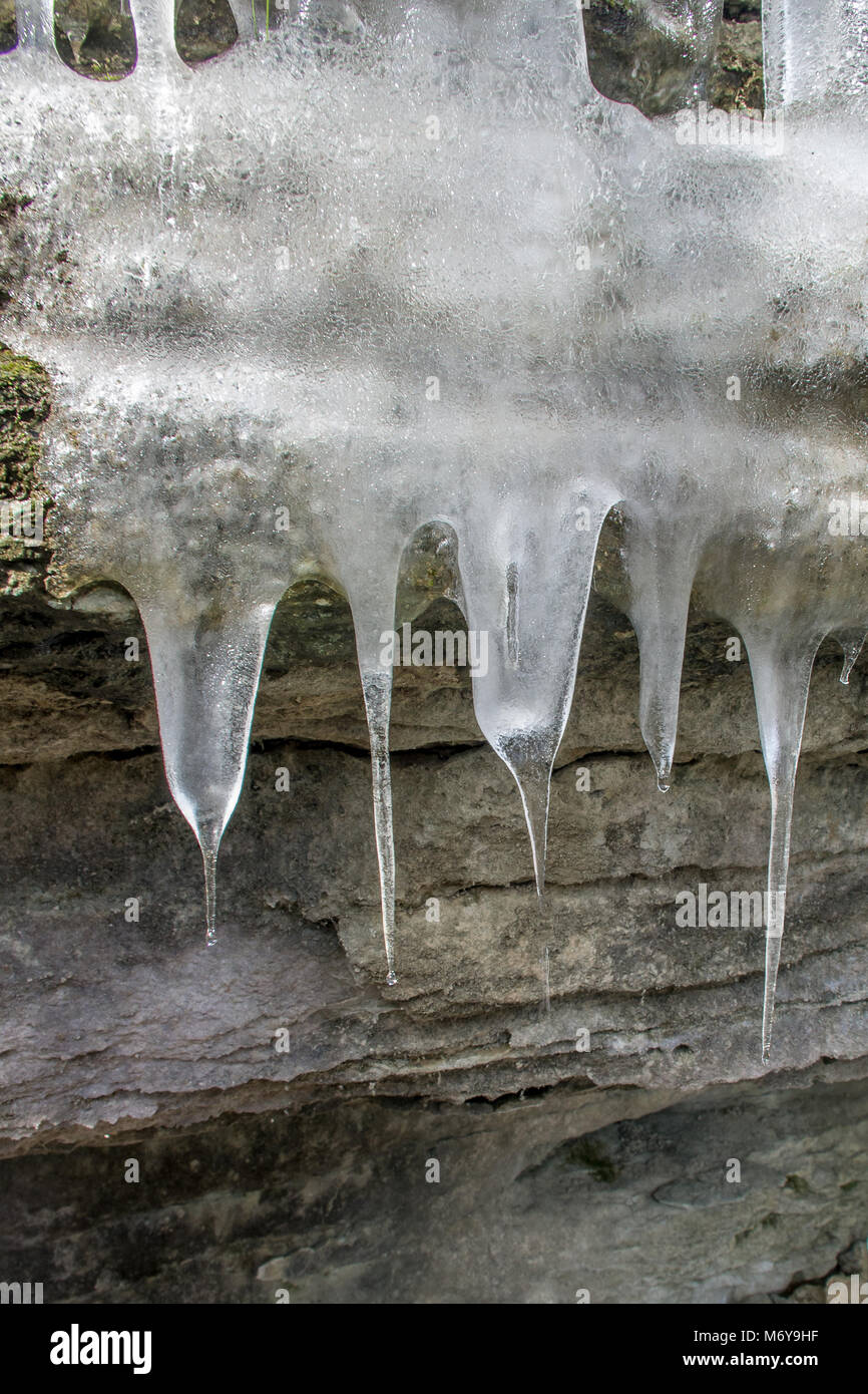 Primo piano di ghiaccioli appesi da una grotta ingresso Foto Stock